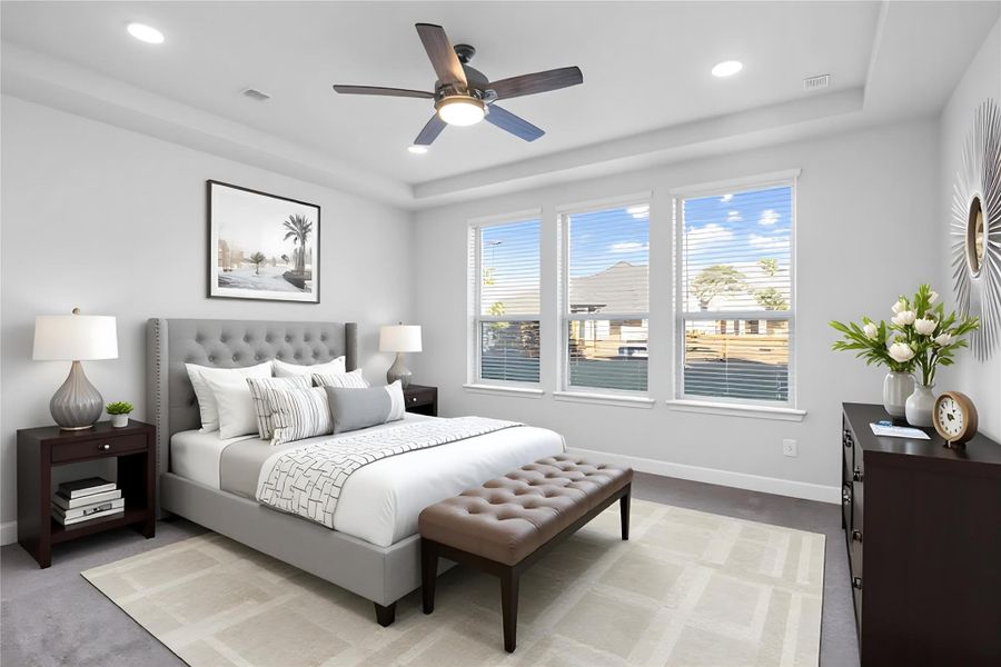 This spacious primary bedroom is an ideal private retreat, offering abundant natural light through multiple large windows and year-round comfort with a modern ceiling fan. The neutral color palette, including soft gray carpeting, creates a calm and inviting atmosphere that provides a perfect blank canvas for new owners to personalize. *Virtually Staged This spacious primary bedroom is an ideal private retreat, offering abundant natural light through multiple large windows and year-round comfort with a modern ceiling fan. The neutral color palette, including soft gray carpeting, creates a calm and inviting atmosphere that provides a perfect blank canvas for new owners to personalize. *Virtually Staged