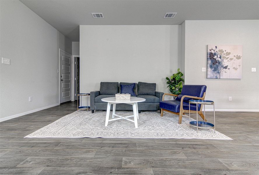 Hardwood-style flooring and a light color palette define this open-concept living area. Hardwood-style flooring and a light color palette define this open-concept living area.