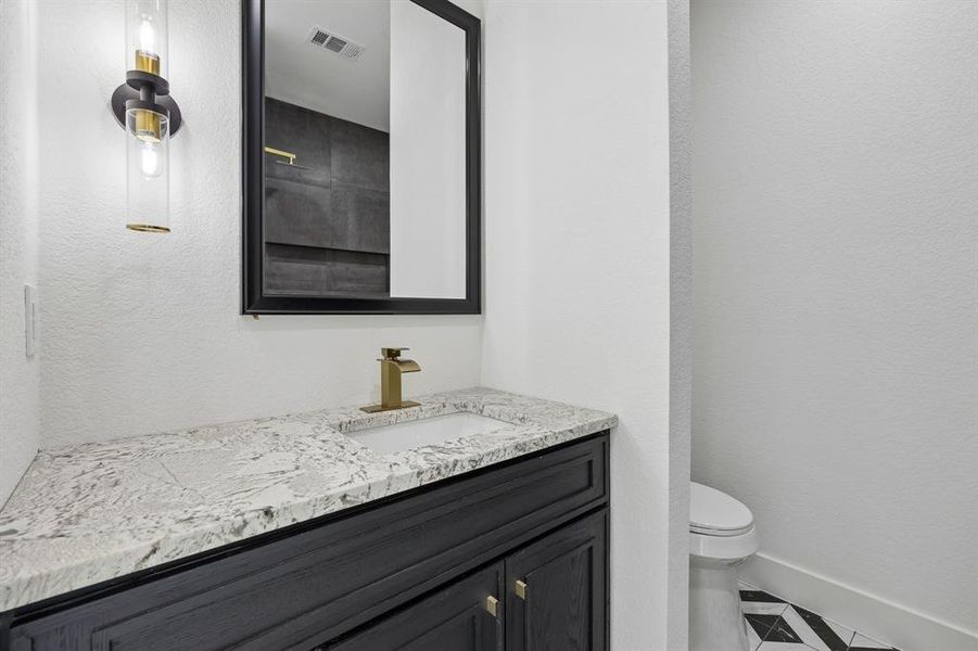 Vanity with white granite countertop, undermount sink, and gold-finish faucet Vanity with white granite countertop, undermount sink, and gold-finish faucet