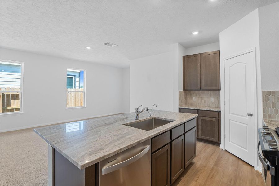 Additional view of the kitchen island displaying the ample storage space and gorgeous granite countertop.