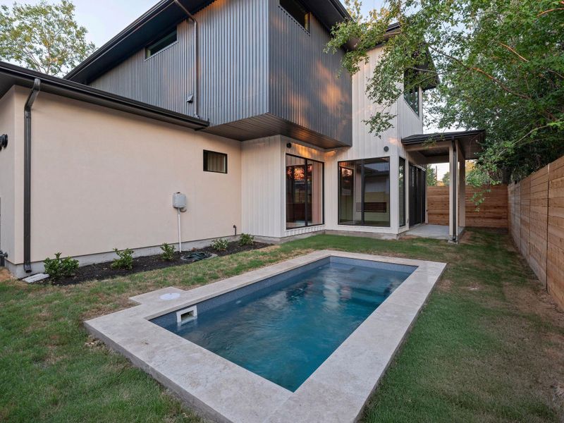 Rear view of property with a patio area, a fenced backyard, and an outdoor pool
