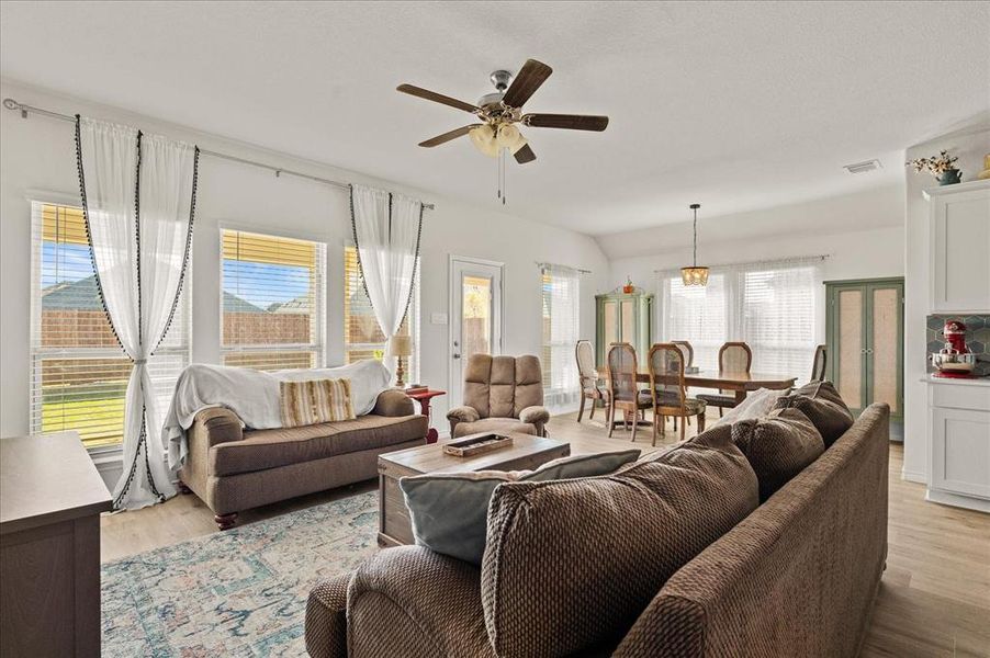 Living room with ceiling fan and light hardwood / wood-style floors