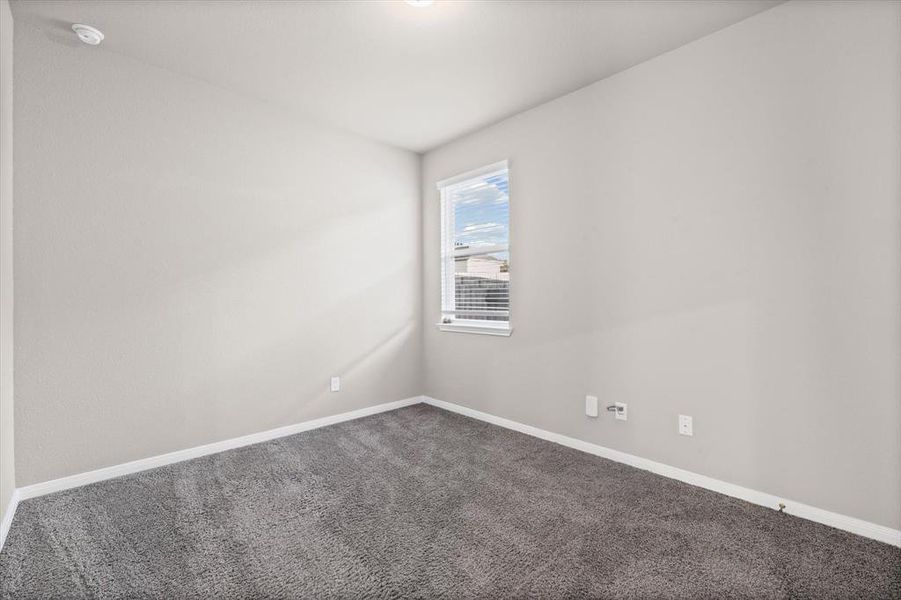 Carpeted spare room featuring baseboards Carpeted spare room featuring baseboards