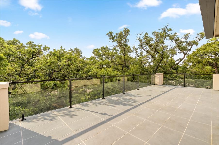 Expansive rooftop terrace set above the tree canopy, offering a serene and private outdoor retreat