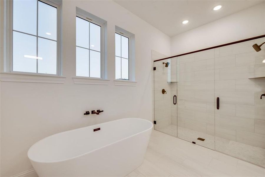 Bathroom featuring a freestanding tub, a stall shower, recessed lighting, and tile patterned floors