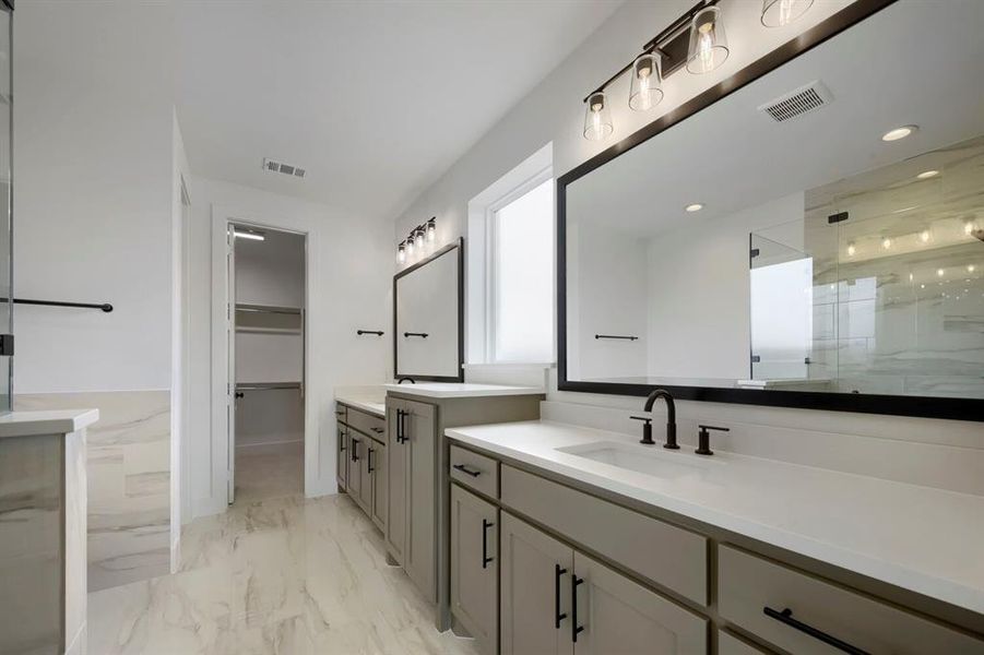 Dual vanity with light gray cabinetry, white countertops, and matte black fixtures Dual vanity with light gray cabinetry, white countertops, and matte black fixtures