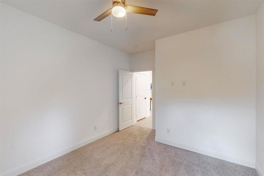 Carpeted empty room with ceiling fan