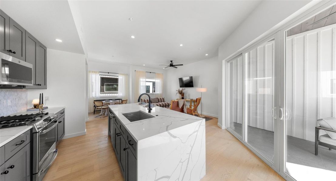 An open living level wrapped in light and flowing to the kitchen — built for connection, conversation, and easy living. Model No. 105 Shown.