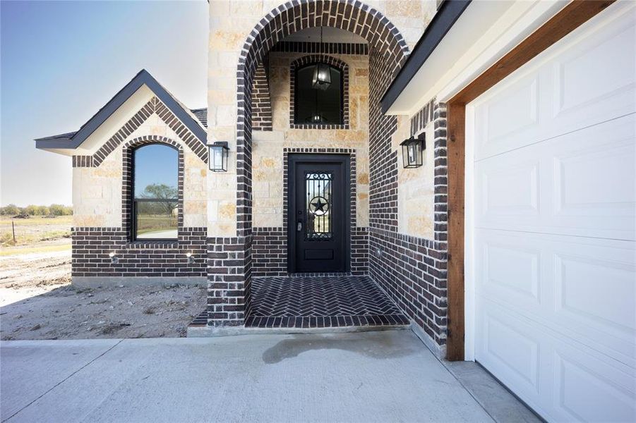 Entrance to property featuring stone siding and brick siding