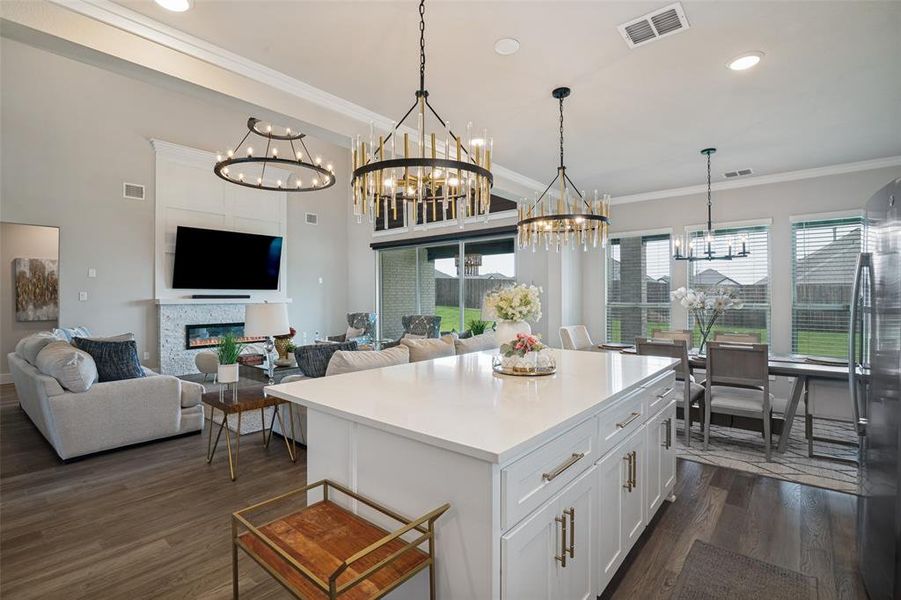 Expansive kitchen island with a light-toned countertop, white cabinetry, and gold-finish hardware