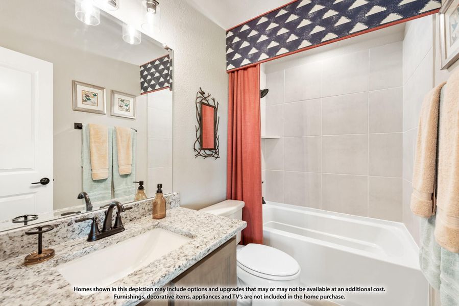 Bathroom with granite vanity, large mirror, and tub-shower combo with coral curtain and patterned valance Bathroom with granite vanity, large mirror, and tub-shower combo with coral curtain and patterned valance