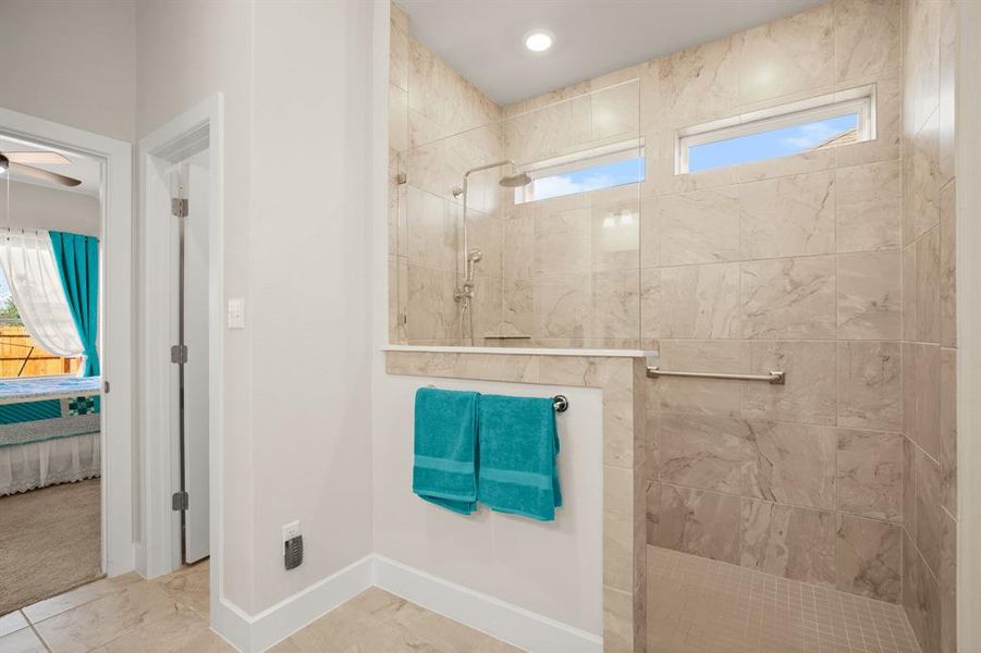 Unwind after a long day in the oversized frameless walk-in shower, providing a spa-like experience right at home.