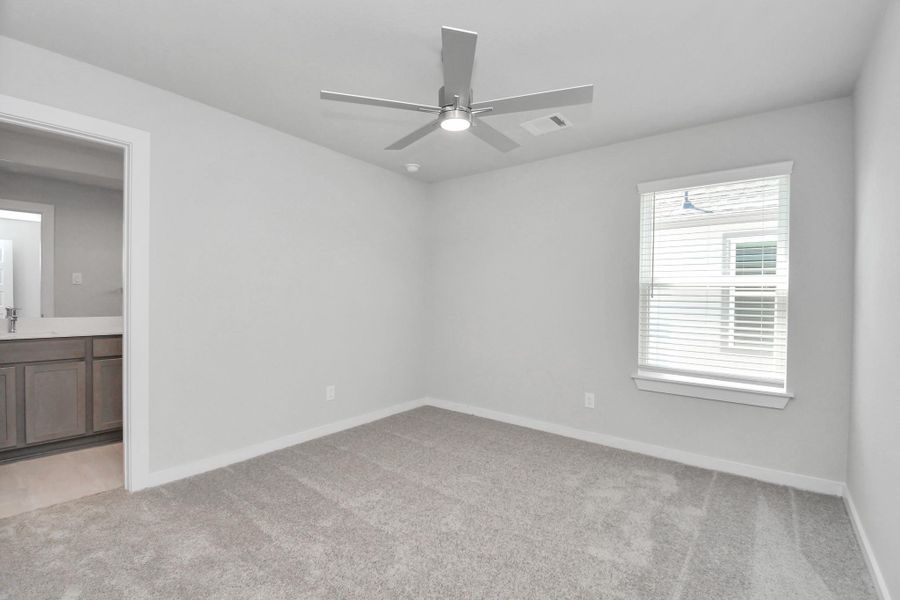 Secondary bedroom features plush carpeting, large windows that let in plenty of natural light, bright paint, and spacious closets.