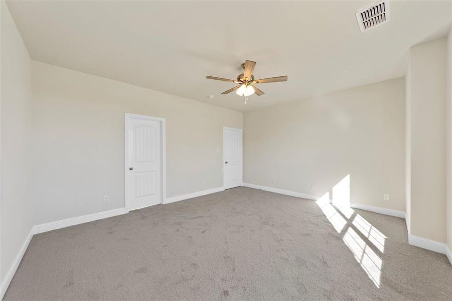 Carpeted spare room featuring ceiling fan