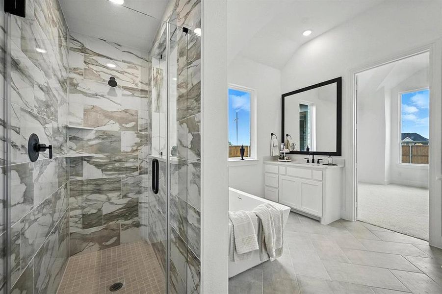 Full bathroom featuring vanity, a marble finish shower, plenty of natural light, and light tile patterned floors