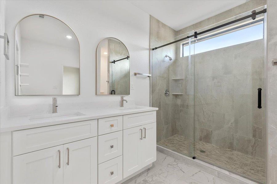 Marble Tile flooring complements a modern glass-enclosed shower and dual vanities in this sleek bathroom. Marble Tile flooring complements a modern glass-enclosed shower and dual vanities in this sleek bathroom.