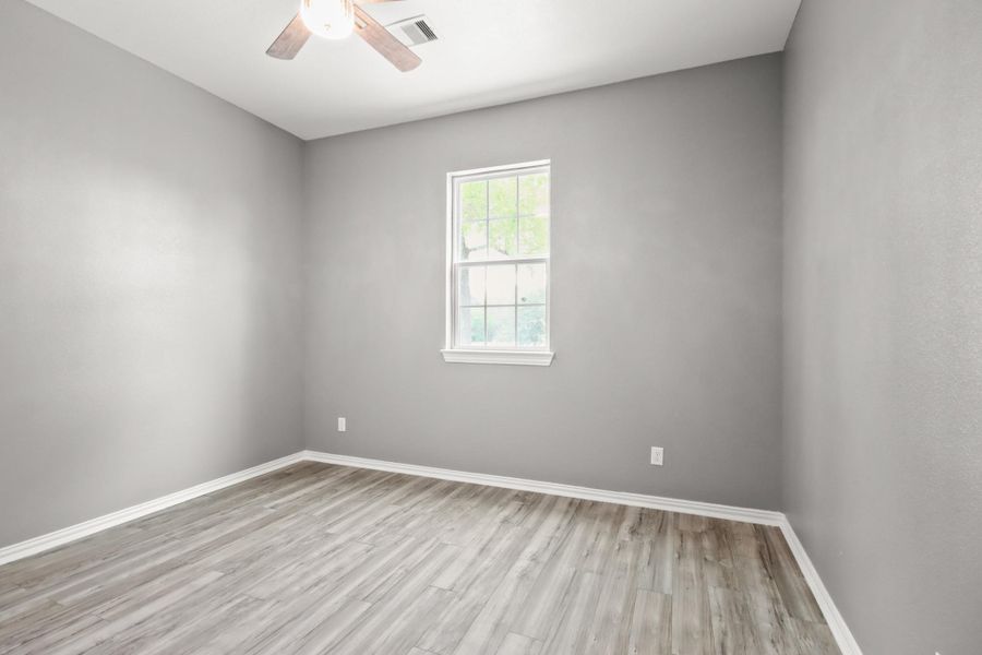 The 2nd bedroom features a natural light and a ceiling fan.