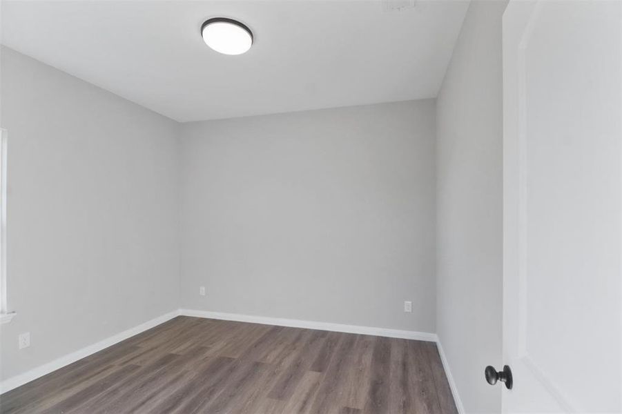 Empty room featuring dark hardwood / wood-style floors