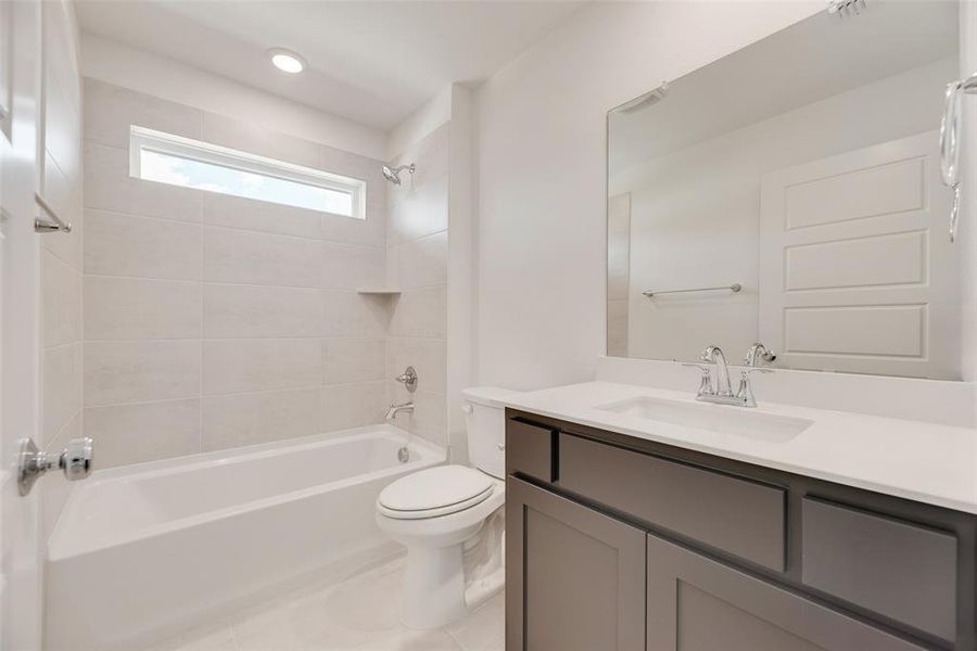 Bathroom with shower / bath combination, vanity, light tile patterned flooring, and recessed lighting Bathroom with shower / bath combination, vanity, light tile patterned flooring, and recessed lighting