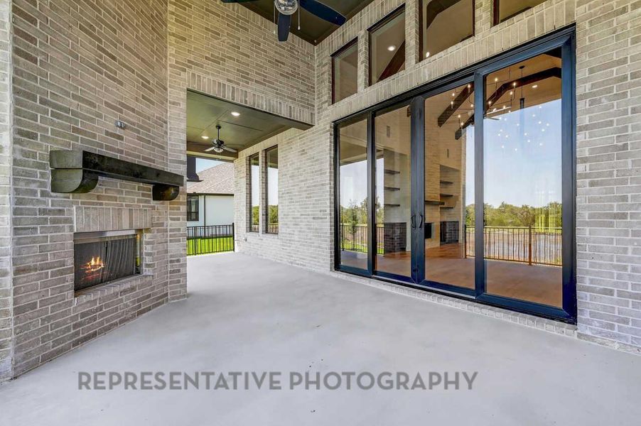 View of patio / terrace featuring an outdoor brick fireplace and a ceiling fan View of patio / terrace featuring an outdoor brick fireplace and a ceiling fan