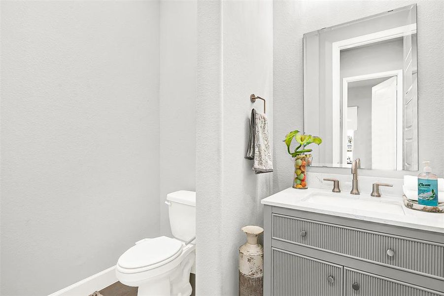 Bathroom featuring a textured wall and vanity