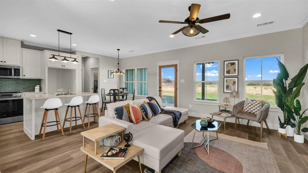 Living room featuring crown molding, light wood-style flooring, plenty of natural light, recessed lighting, and a ceiling fan