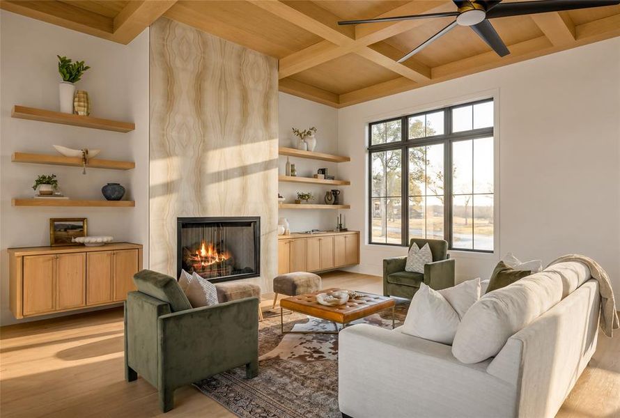 Living area featuring a floor-to-ceiling fireplace with an integrated firebox, wood-finish coffered ceiling, and large black-framed windows
