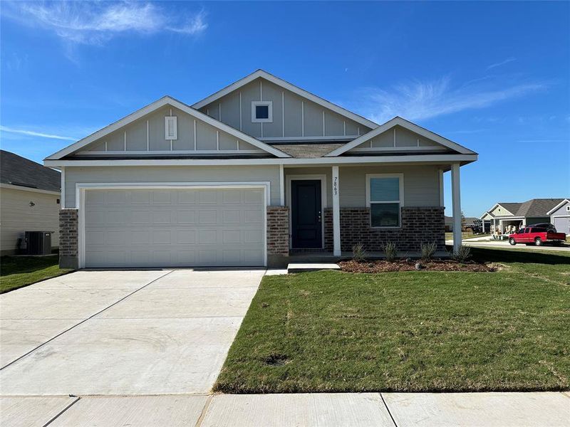 Craftsman-style home with a front lawn, central AC unit, and a garage