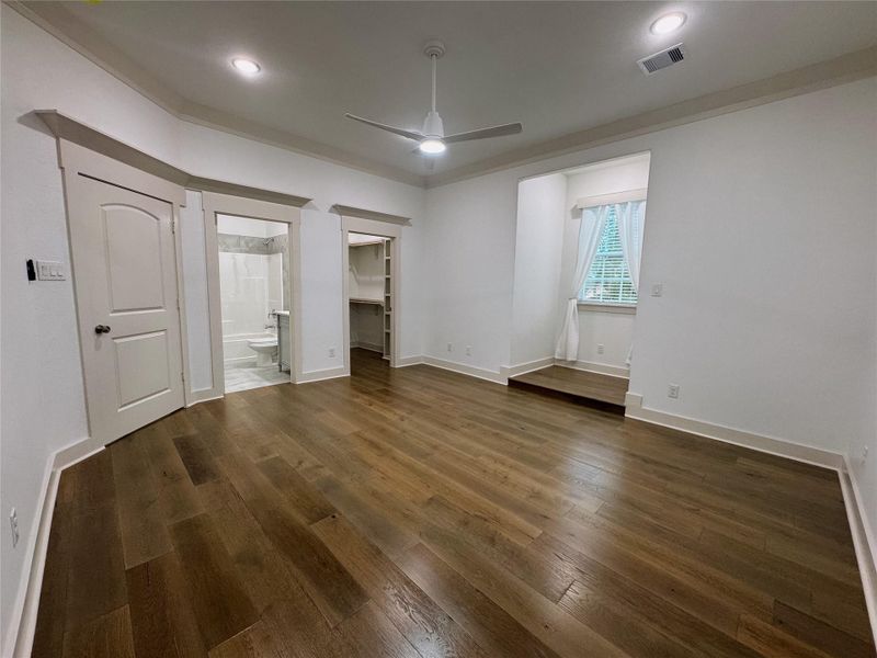Secondary bedroom has wood floors, walk-in closet and bathroom