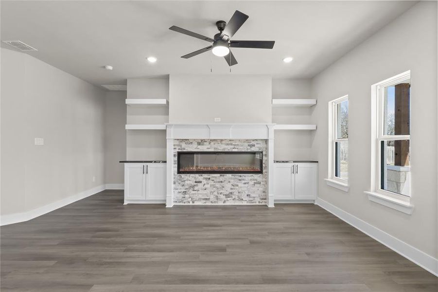 Unfurnished living room with dark wood-type flooring and ceiling fan