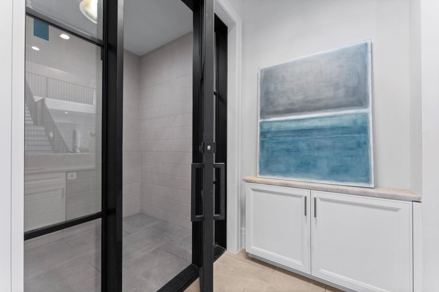 Additional view of the temperature-controlled wine room, featuring a wrought-iron and glass door Additional view of the temperature-controlled wine room, featuring a wrought-iron and glass door