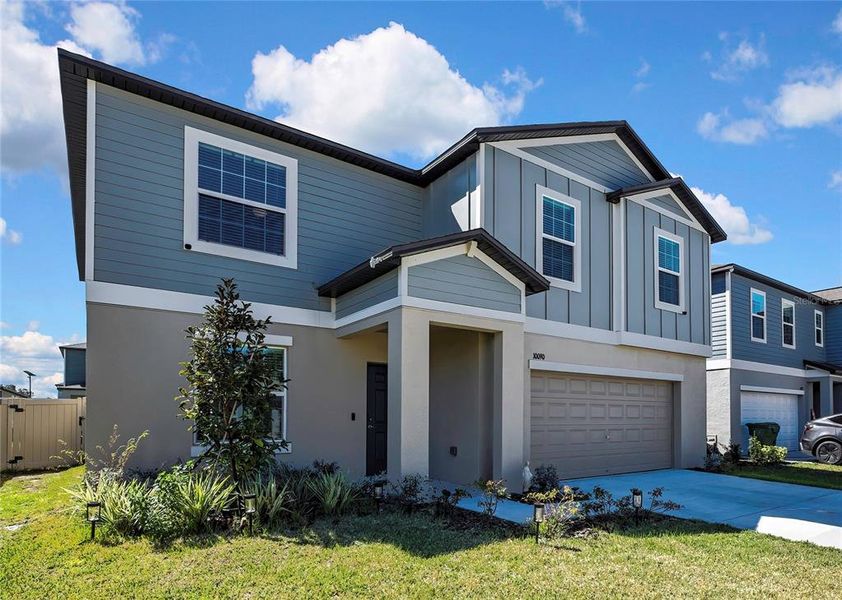 Front exterior of a new home in Angeline: The Estates, Land O' Lakes, FL, highlighting curb appeal (Image 1).