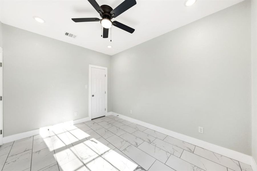 Unfurnished room featuring a ceiling fan, recessed lighting, and light marble finish flooring