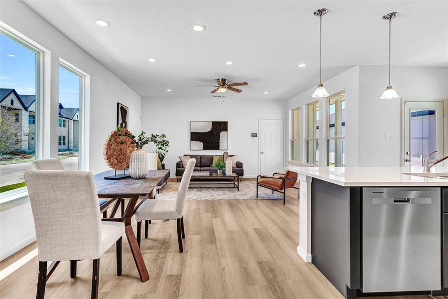 Dining space featuring sink, ceiling fan, and light wood-type flooring