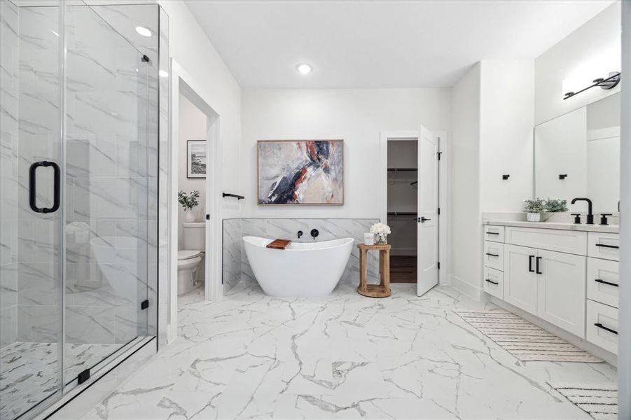 Spa-like en-suite bathroom located in the primary suite offers a large walk-in glass shower, freestanding soaking tub, two sinks and large Quartz vanity top, self closing drawers and cabinets, separate toilet room and large walk-in closet.