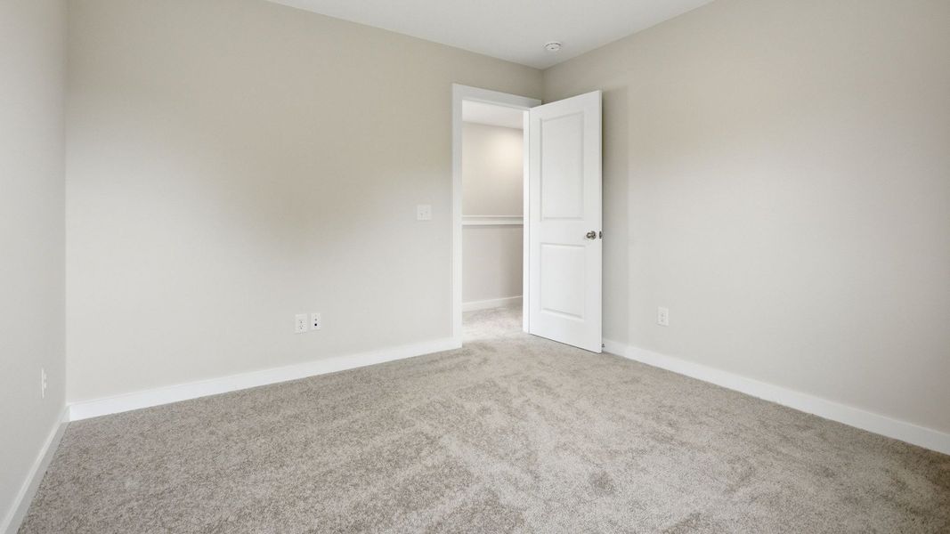 Bedroom with carpet and nearby stairs Bedroom with carpet and nearby stairs
