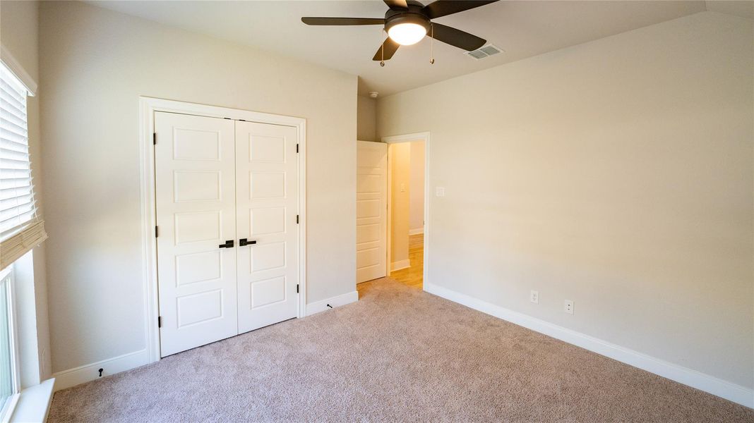 Unfurnished bedroom with a closet, carpet flooring, and a ceiling fan Unfurnished bedroom with a closet, carpet flooring, and a ceiling fan