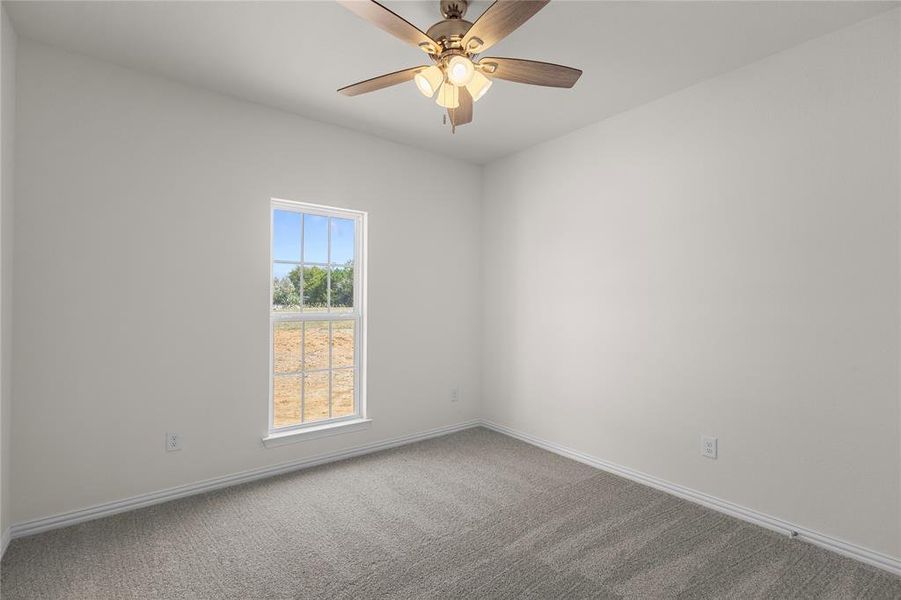 Carpeted empty room with baseboards and ceiling fan