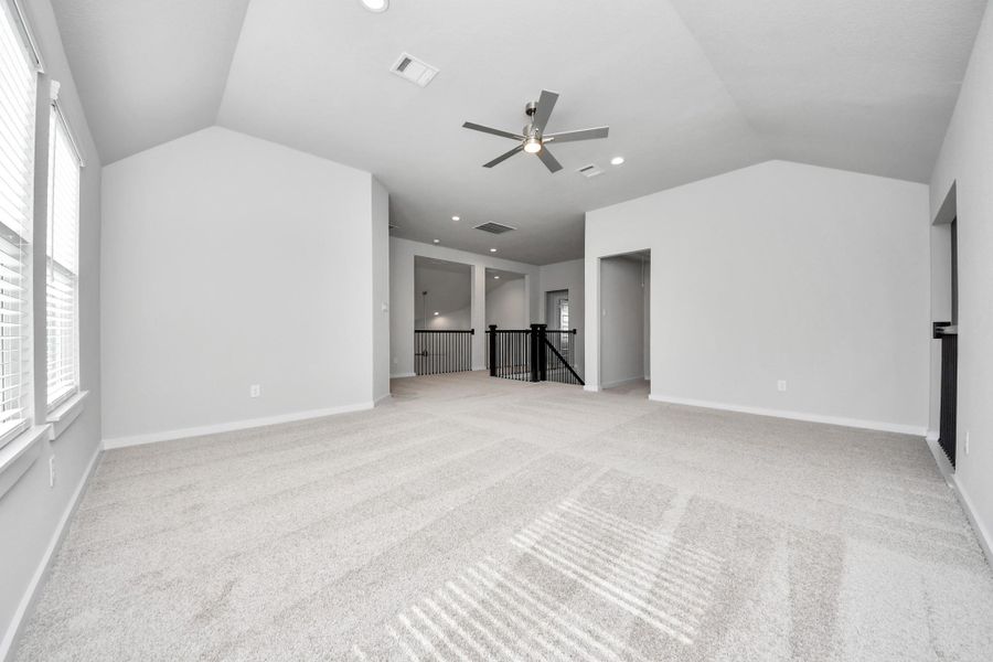 Discover a haven of leisure in this fantastic game room! Whether you're seeking a casual hangout or an adult gaming retreat, this space has it all. Enjoy the luxurious feel of plush carpet underfoot, the expansive ambiance of high ceilings, custom paint that adds a touch of personality, and windows that flood the room with refreshing natural light.