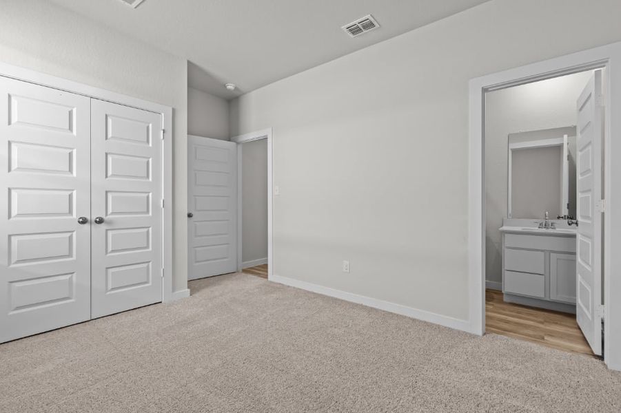 A bathroom with white cabinets.