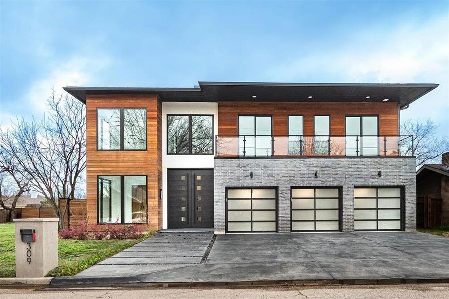 Contemporary exterior showcasing wood paneling, light gray brick, and large black-framed windows Contemporary exterior showcasing wood paneling, light gray brick, and large black-framed windows