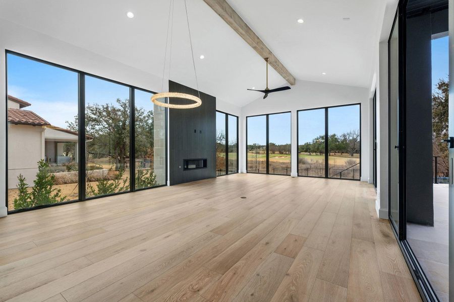 Unfurnished living room featuring light wood-type flooring, vaulted ceiling, and healthy amount of natural light