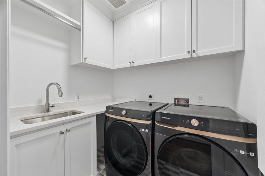Utility room is conveniently located by the primary suite with sink.
