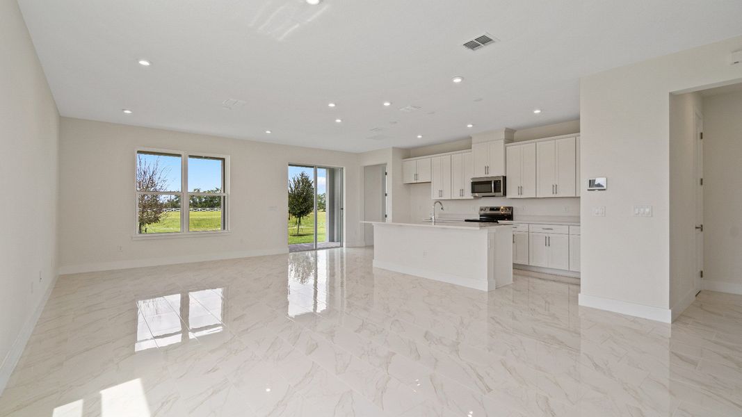 The Sweetgum Spacious and Bright Kitchen and living area in two story home in Trailside in Mount Dora by DRB Homes