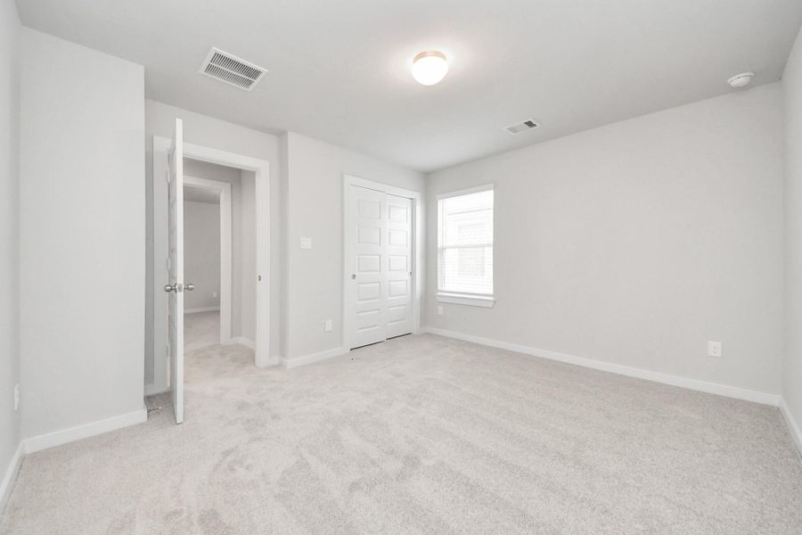 Generously sized secondary bedrooms featuring spacious closets, soft and inviting carpeting underfoot, large windows allowing plenty of natural light, and the added touch of privacy blinds for your personal retreat. Sample photo of completed home with similar floor plan. Actual colors and selections may vary.