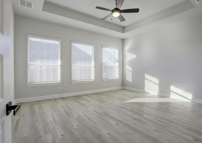 Breathtaking master bedroom with large windows and a high ceiling.