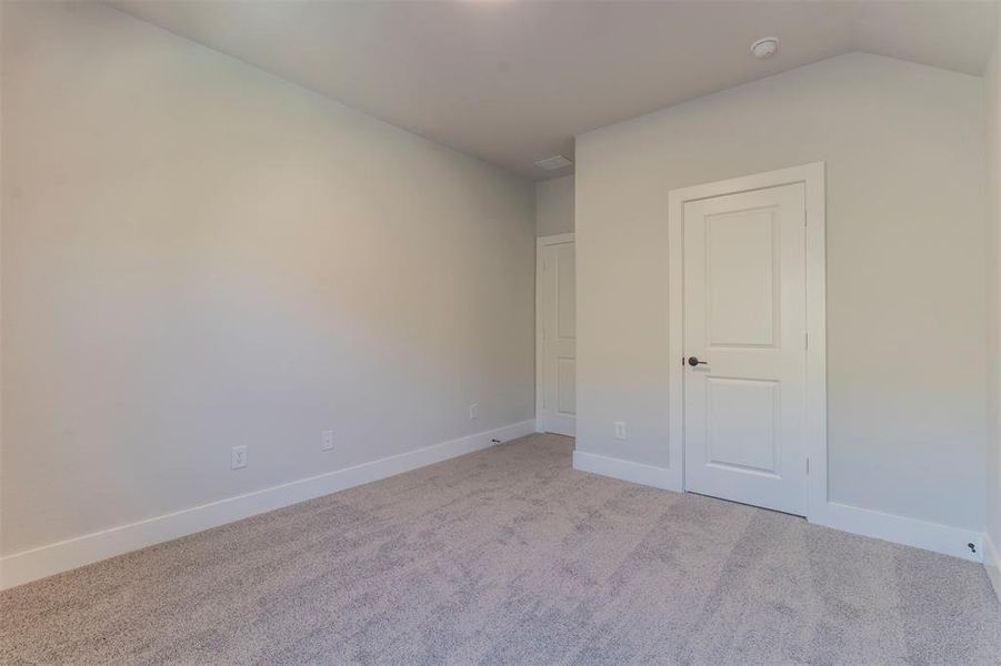 Unfurnished bedroom featuring light carpet and baseboards