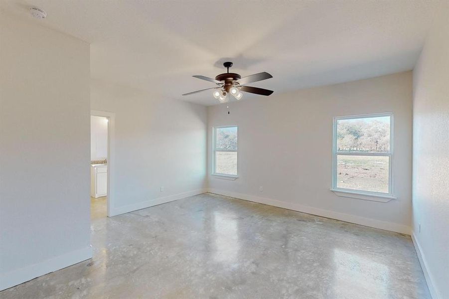 Unfurnished room featuring ceiling fan and a healthy amount of sunlight