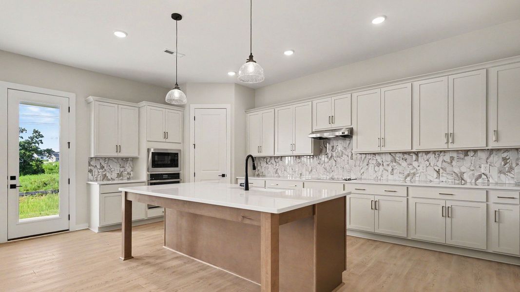 Huge kitchen with quartz countertops and accent backsplash, with a corner pantry and tons of workspace
