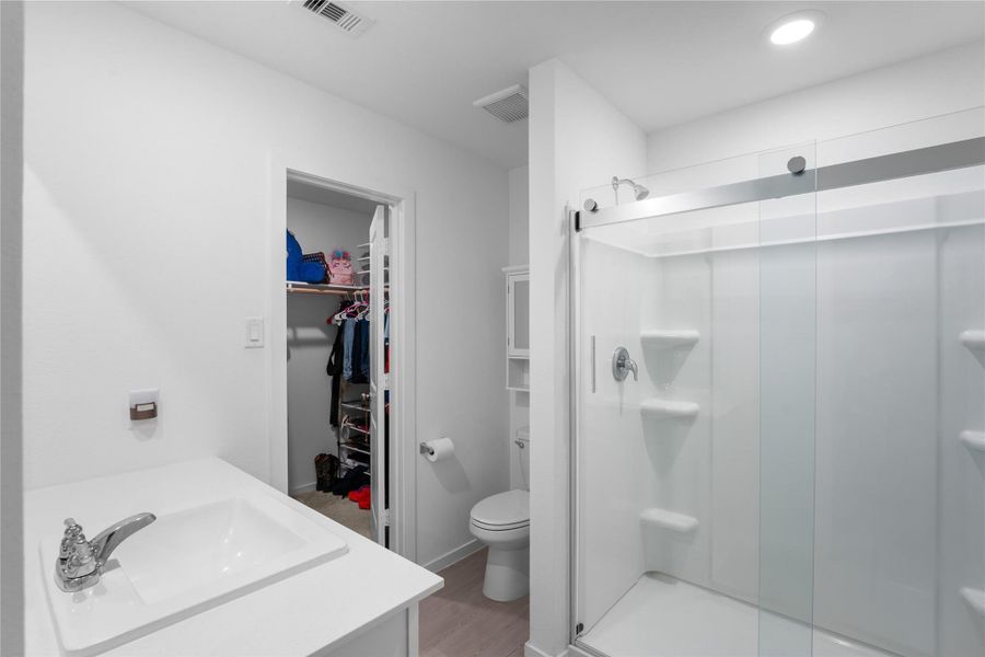 Glass sliding shower door adds a clean, functional touch to the en-suite.